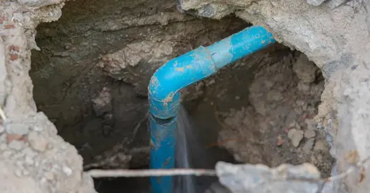 Leaking water from blue pipe from underground